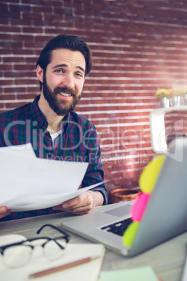 Portrait of smiling creative businessman with documents