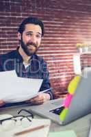 Portrait of smiling creative businessman with documents