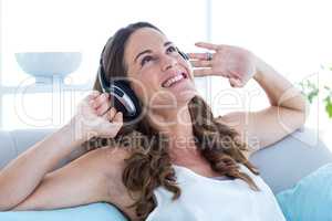 Smiling woman listening music at home