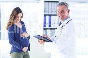 Male doctor with pregnant woman in clinic
