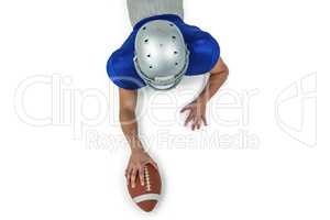 Rear view of American football player lying in front with ball