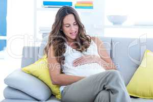 Happy pregnant woman with hands on stomach