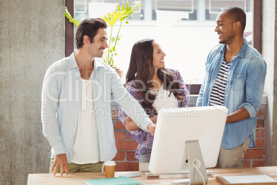 Business people smiling while pointing towards computer