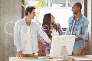 Business people smiling while pointing towards computer