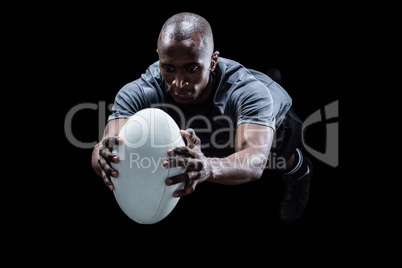 Rugby player jumping while catching ball