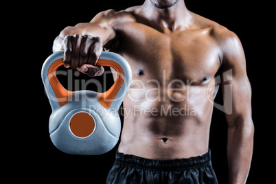 Mid section of muscular man holding kettlebell