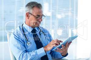 Male doctor using digital tablet in clinic