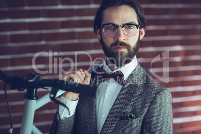 Portrait of confident hipster carrying bicycle