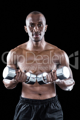 Portrait of confident athlete holding dumbbell