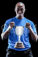 Portrait of happy sportsman holding trophy