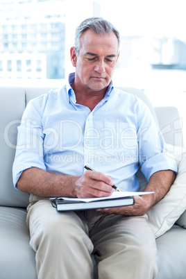 Businessman writing on notepad at office