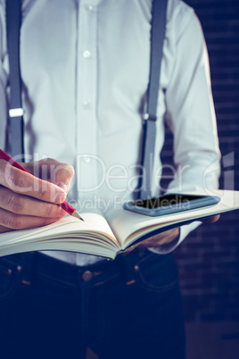 Businessman planning with help of cellphone and book