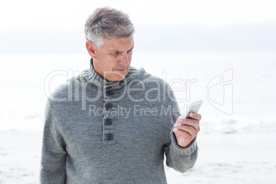 Smiling man standing and on his phone