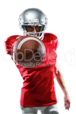 Confident American football player in red jersey holding ball