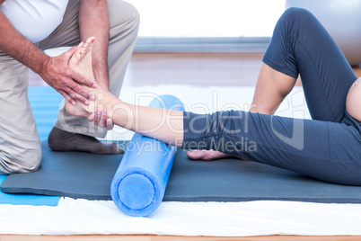Low section of instructor teaching exercise to pregnant woman