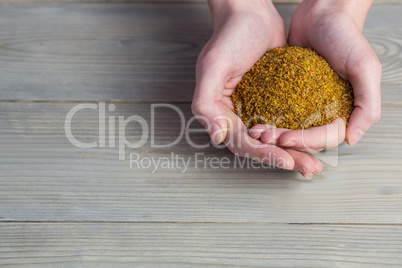 Woman showing handful of milled seed