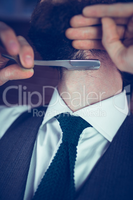 Midsection of man shaving beard