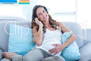Portrait of pregnant woman listening to music
