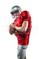 Serious American football player in red jersey holding ball