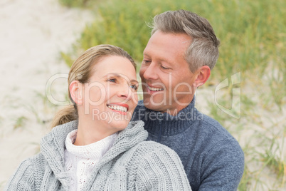 Smiling couple sitting on the sand