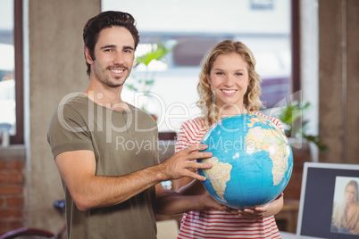 Portrait of business people holding globe