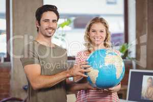 Portrait of business people holding globe