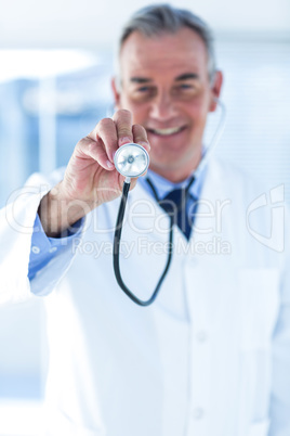 Smiling male doctor examining with stethoscope