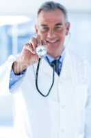 Smiling male doctor examining with stethoscope