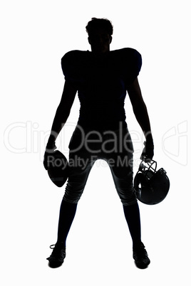 Silhouette American football player holding ball and helmet
