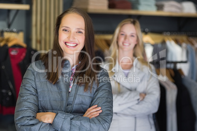 Pretty brunette with arms crossed looking at camera with friend