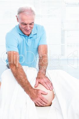 Therapist smiling while massaging belly of pregnant woman