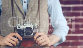 Midsection of hipster holding camera