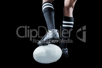 Sportsman keeping leg on ball while playing rugby