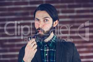 Portrait of serious man with smoking pipe