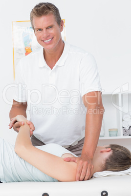 Doctor stretching a young woman back
