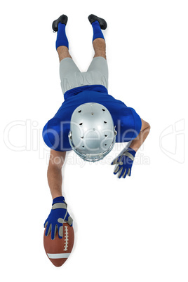 Full length rear view of American football player reaching towar