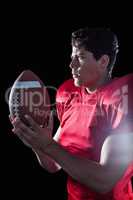Serious sportsman holding American football