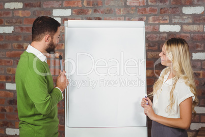 Business people discussing over flip chart