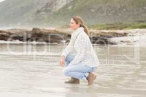 Woman crouching at the shore