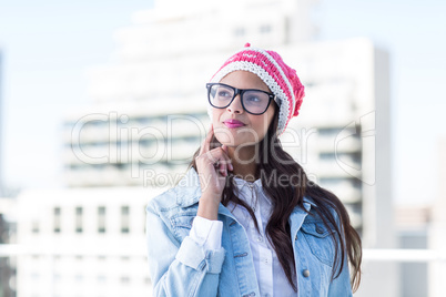 Thoughtful woman looking up with finger on cheek