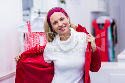 Smiling woman putting on red coat
