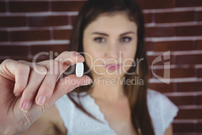Pretty woman showing white pill