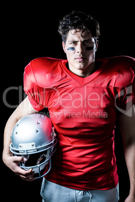 Portrait of determined sportsman holding helmet