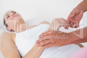 Physiotherapist examining her patient hand