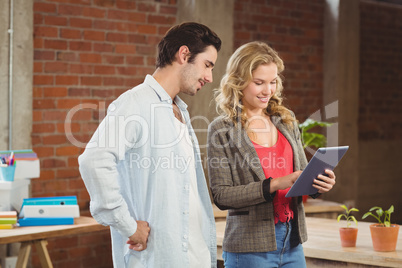Businessman looking at digital tablet and woman gesturing in off