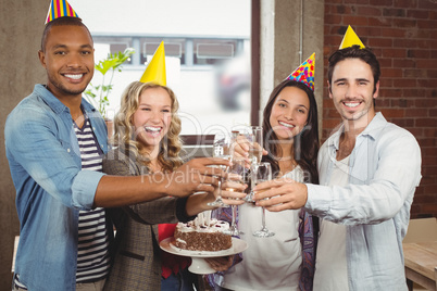 Portrait of happy colleagues toasting with champagne