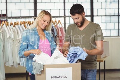 Volunteers looking at clothes in donation box