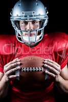 Close-up portrait of confident sportsman holding American footba