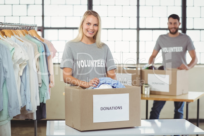 Volunteer separating clothes from donation box
