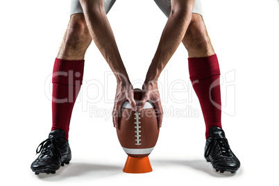 Low section of sports player placing the ball